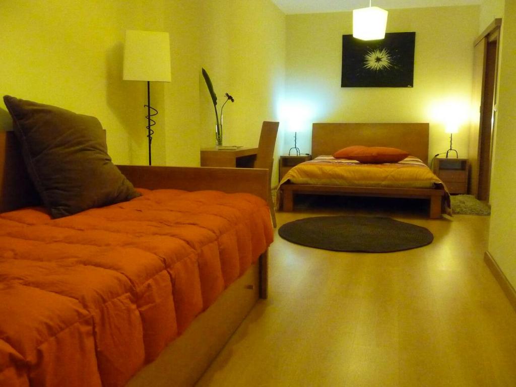 a bedroom with two beds and a lamp and a rug at 2 bedrooms house at Vila de Rei in Vila de Rei