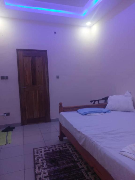a bedroom with two beds and a blue light at Castor in Ziguinchor