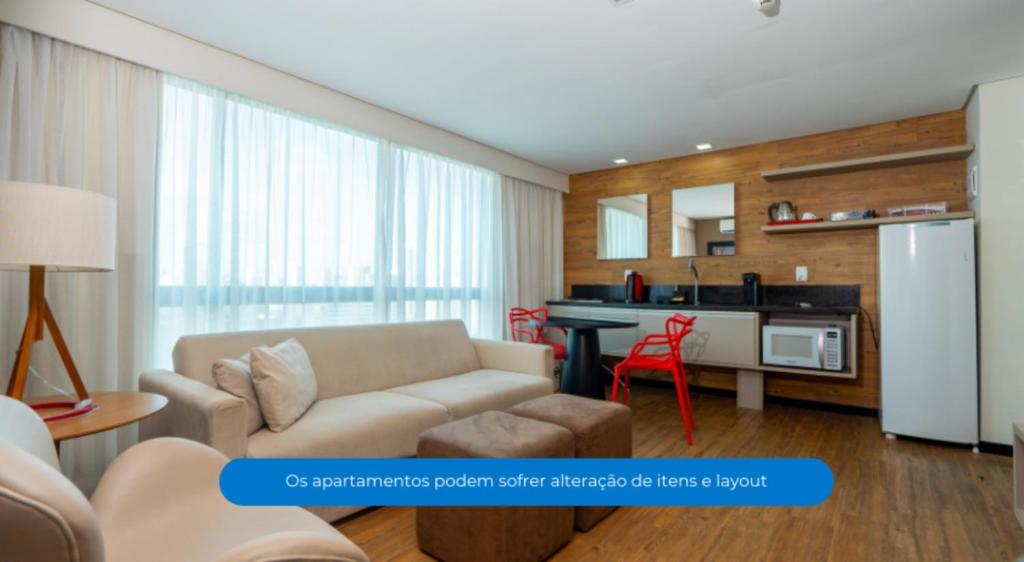 a living room with a couch and a kitchen at Roomo Praia de Boa Viagem Residencial in Recife