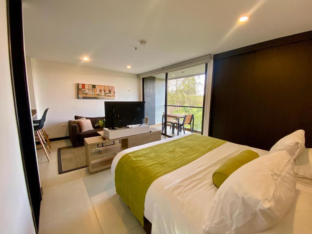 1 dormitorio con 1 cama grande y sala de estar en Apartaestudio en hotel en Rionegro