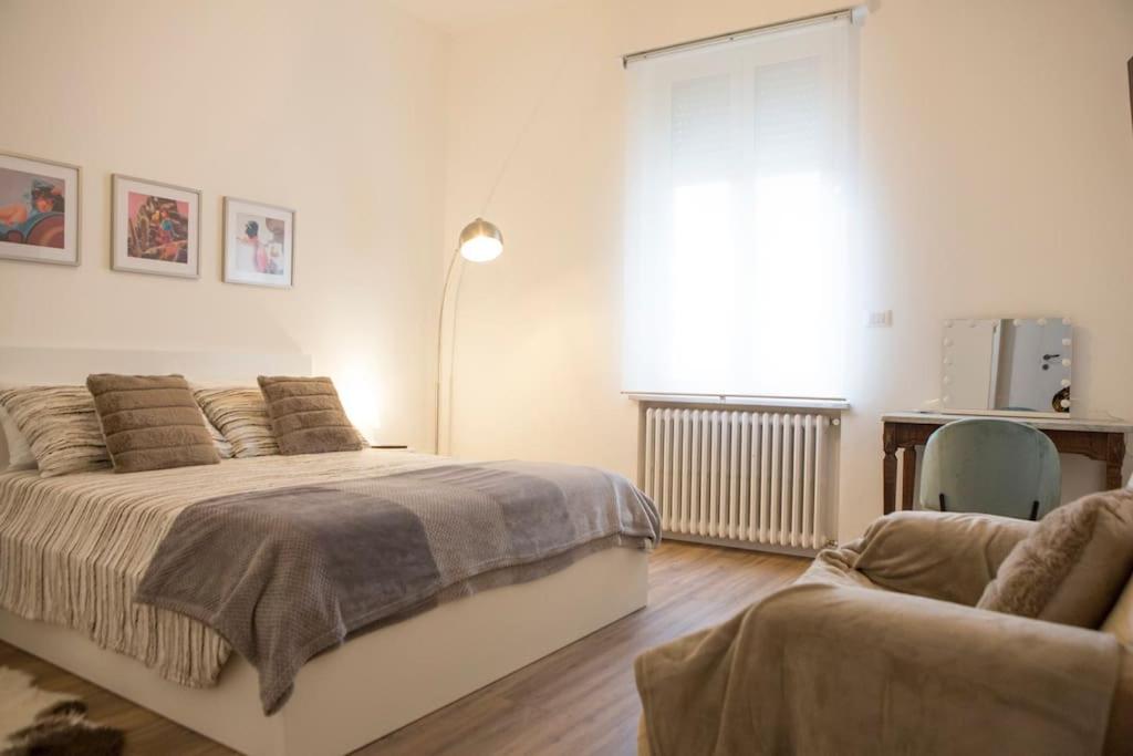 a bedroom with a bed and a couch and a window at Casa Boschi in centro città in Pescara