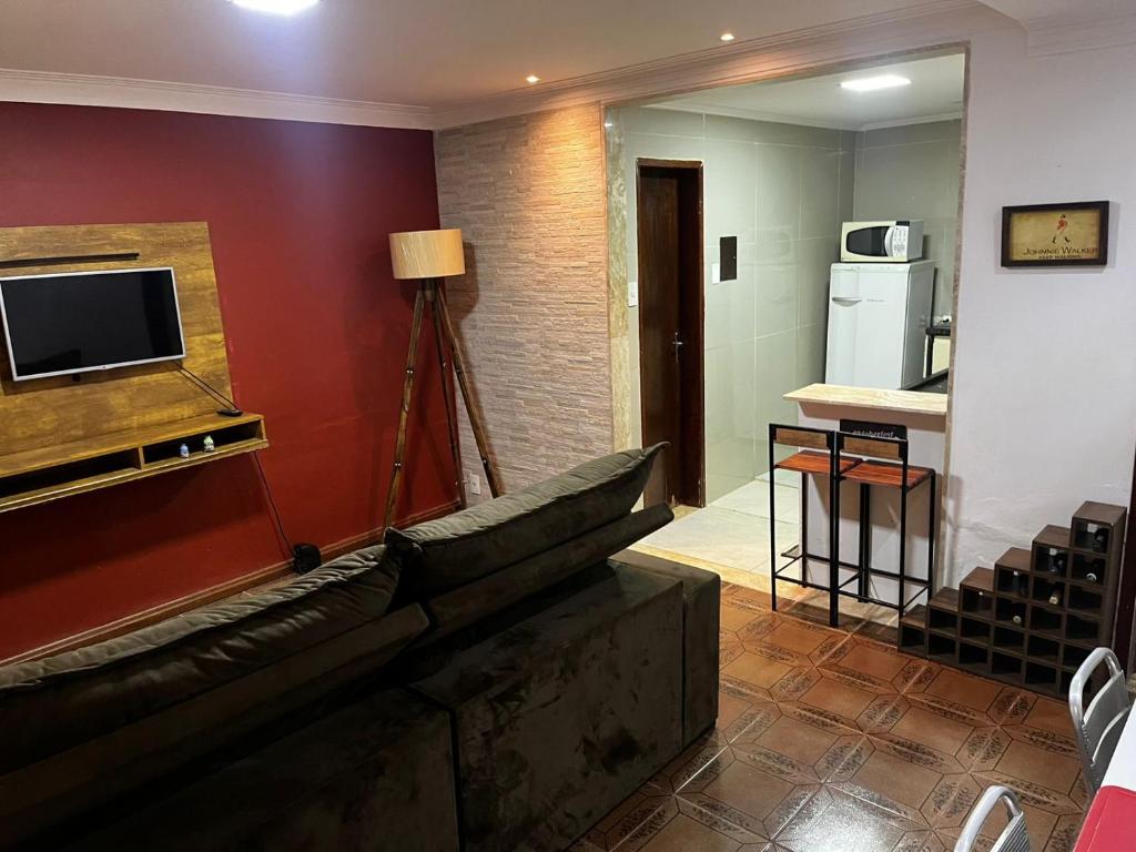 a living room with a couch and a television at Linda Casa com Estacionamento in Juiz de Fora
