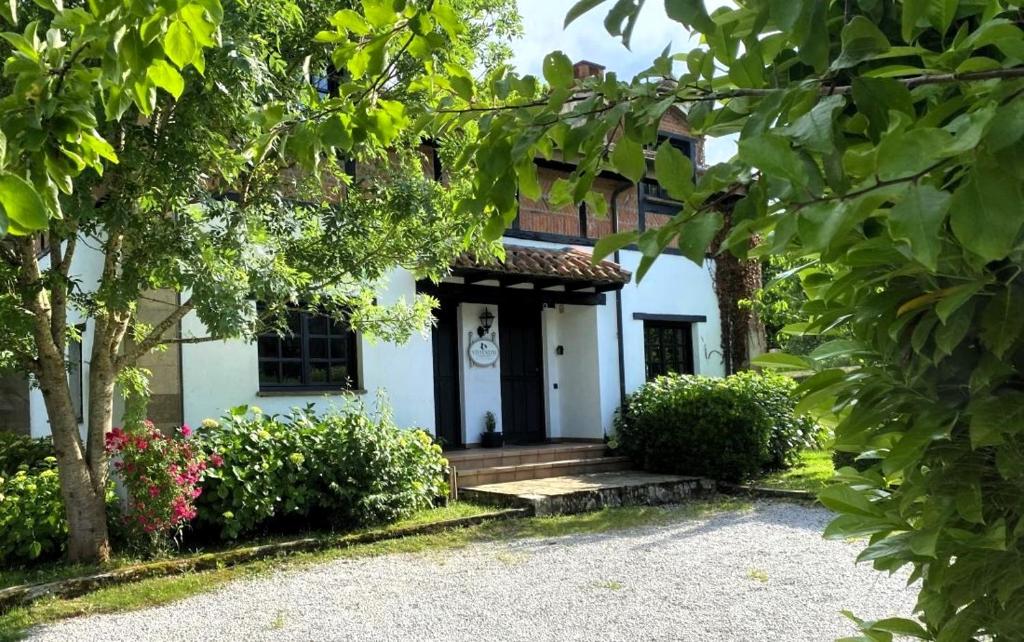 Casa blanca con porche y puerta en Casa Rural El Pozo Tremeo, en Soña