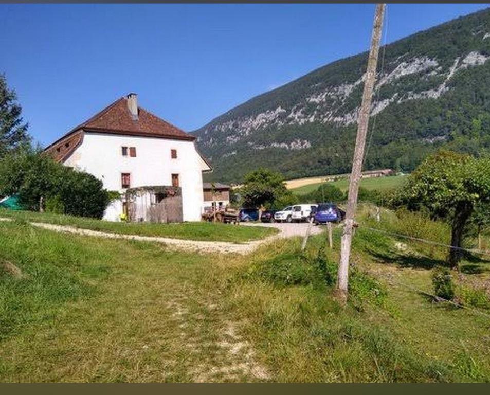 une maison blanche avec des voitures garées devant une montagne dans l'établissement Chez Dodo 2534 Orvin Le Foncet, à Evilard