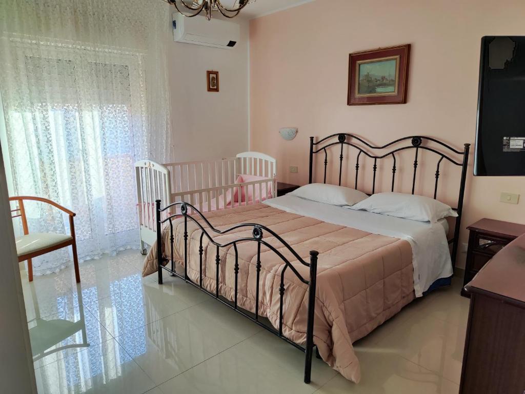 a bedroom with a bed with two cribs at Trapani love in Trapani