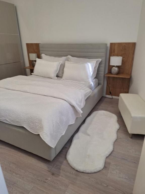 a bedroom with a large bed with white sheets and pillows at Apartman DJ in Đakovo