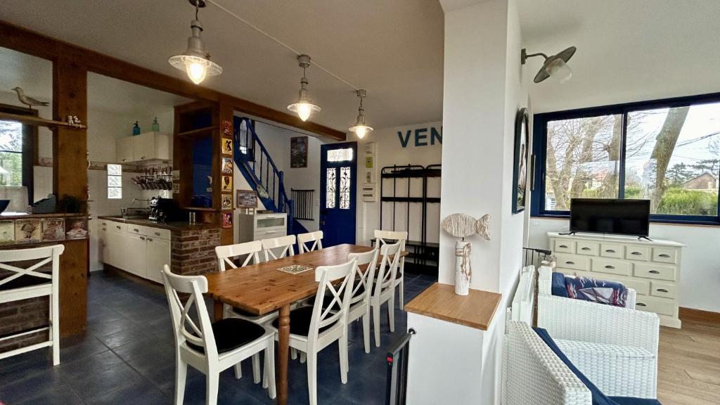 eine Küche und ein Esszimmer mit einem Holztisch und Stühlen in der Unterkunft Sans Souci, maison familiale pour 8 personnes in Cayeux-sur-Mer