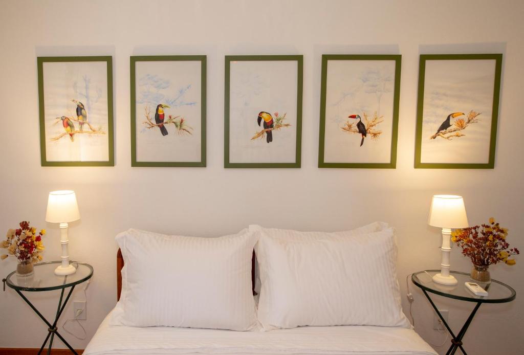 sypialnia z czterema zdjęciami narciarzy na ścianie w obiekcie Suites Caipira Vale das Videiras w mieście Araras Petrópolis
