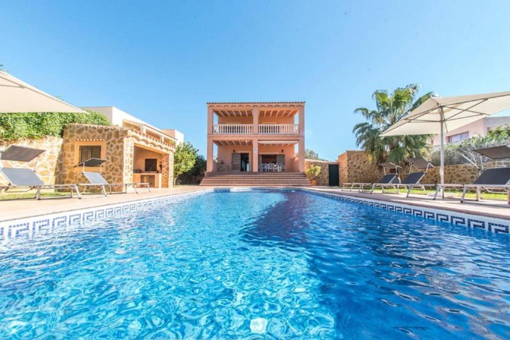 a swimming pool in front of a villa at 4 bedrooms villa with private pool terrace and wifi at Sant Josep de sa Talaia 2 km away from the beach in Sant Jordi