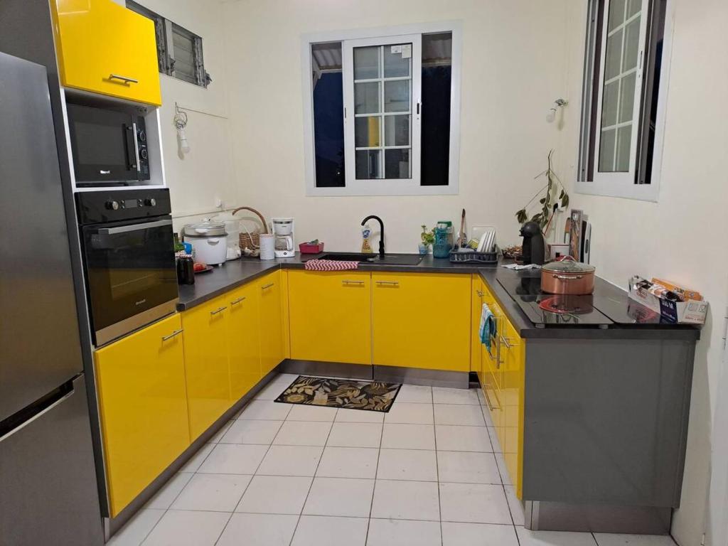 a kitchen with yellow cabinets and a yellow refrigerator at Appartement d'une chambre avec wifi a Le Vauclin in Le Vauclin