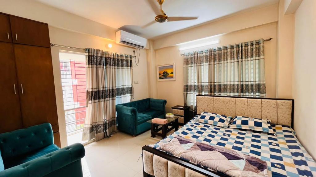 a bedroom with a bed and two green chairs at Entire place-4BHK Apartment Bashundhara R/A in Dhaka