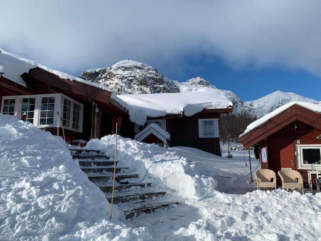 uma casa coberta de neve com um monte de escadas em Roni Chalet Hemsedal - Holdeskaret em Hemsedal