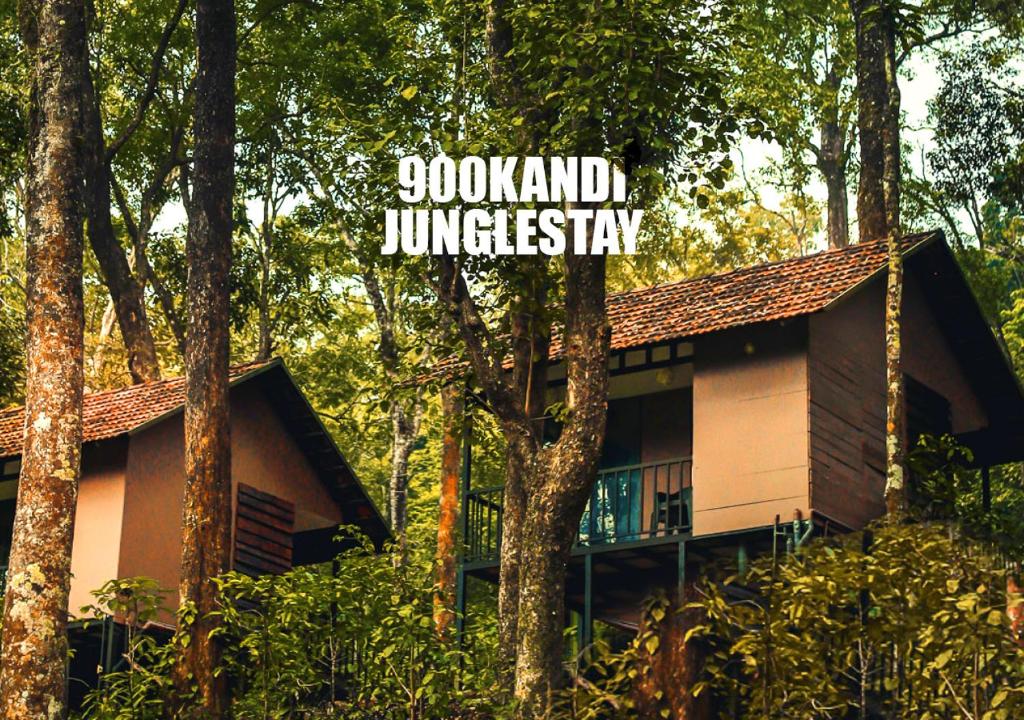 una casa en el bosque con una señal que lee Godland Junglestay en Jungle Woods 900kandi, en Wayanad