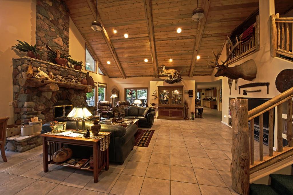 uma grande sala de estar com lareira de pedra em Rocky Point Ranch em Eddy