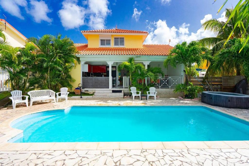 a house with a swimming pool in front of a house at Maison de 7 chambres avec piscine privee terrasse et wifi a Sainte Anne in Sainte-Anne