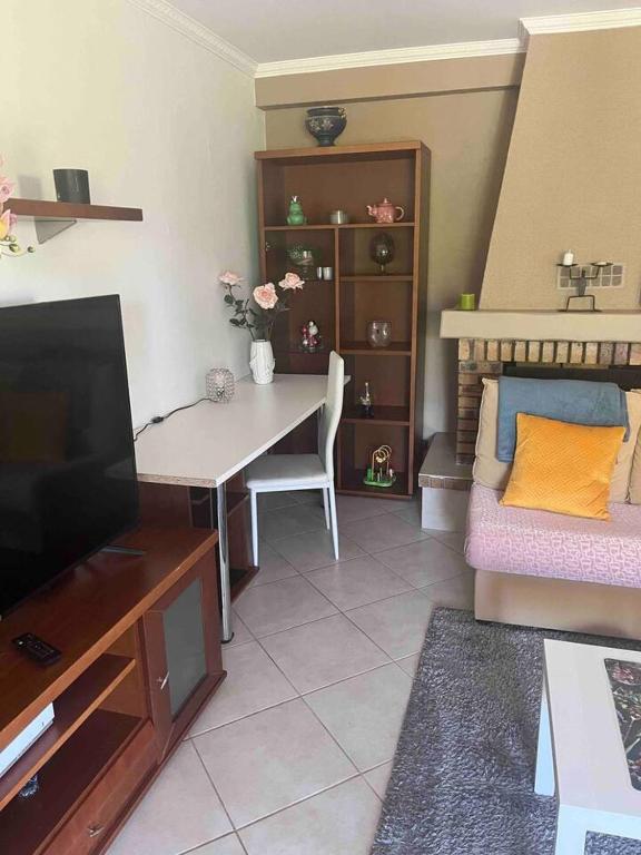 - un salon avec une table, un canapé et une télévision dans l'établissement Maison accueillante à Vigneux-sur-Seine avec parking privé, à Vigneux-sur-Seine