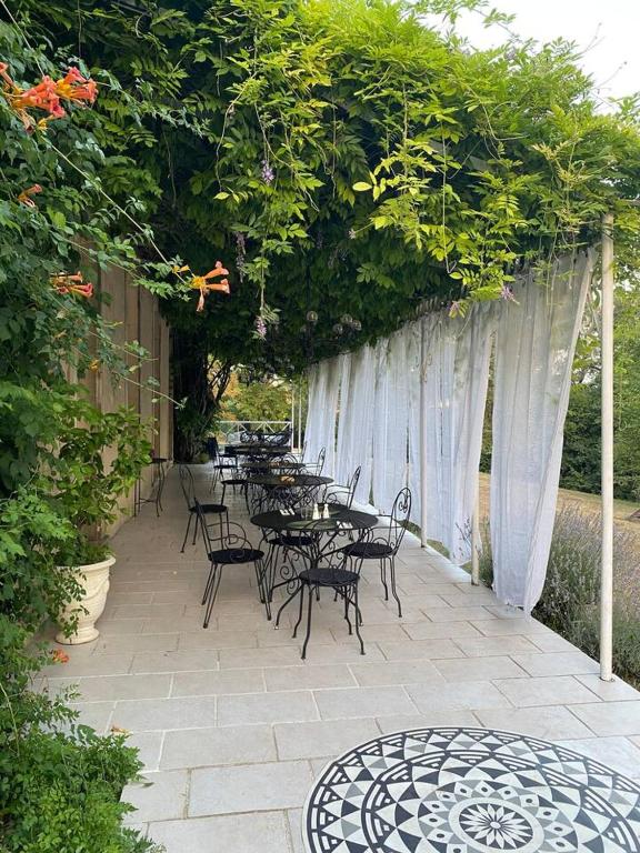 un groupe de tables et de chaises sur une terrasse dans l'établissement Manoir 4 étoiles à Pech-Luna avec piscine privée et cheminée, à Pech-Luna