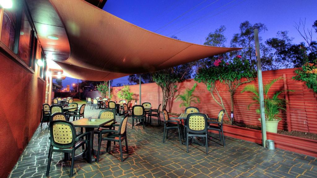 a patio with tables and chairs in a restaurant at Halls Creek Motel in Halls Creek