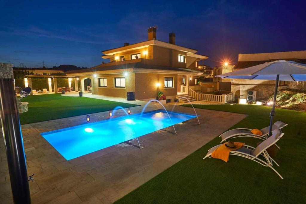 una casa con piscina en el patio por la noche en 5 bedrooms villa with private pool sauna and terrace at Vinaixa en Viñaixa