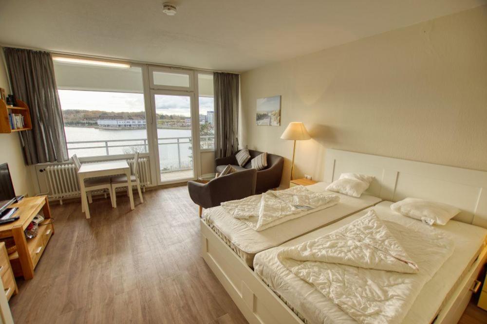 - une chambre avec un lit, un bureau et une fenêtre dans l'établissement Strandhotel, App 1SH308, à Heiligenhafen