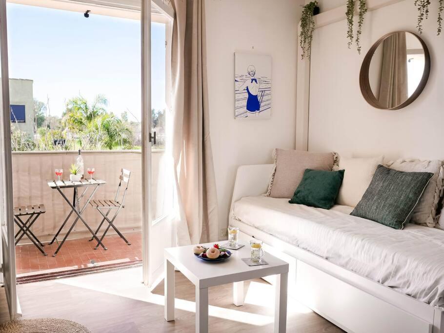 ein Wohnzimmer mit einem weißen Sofa und einem Tisch in der Unterkunft Appartement détente avec vue sur le petit port in Hyères