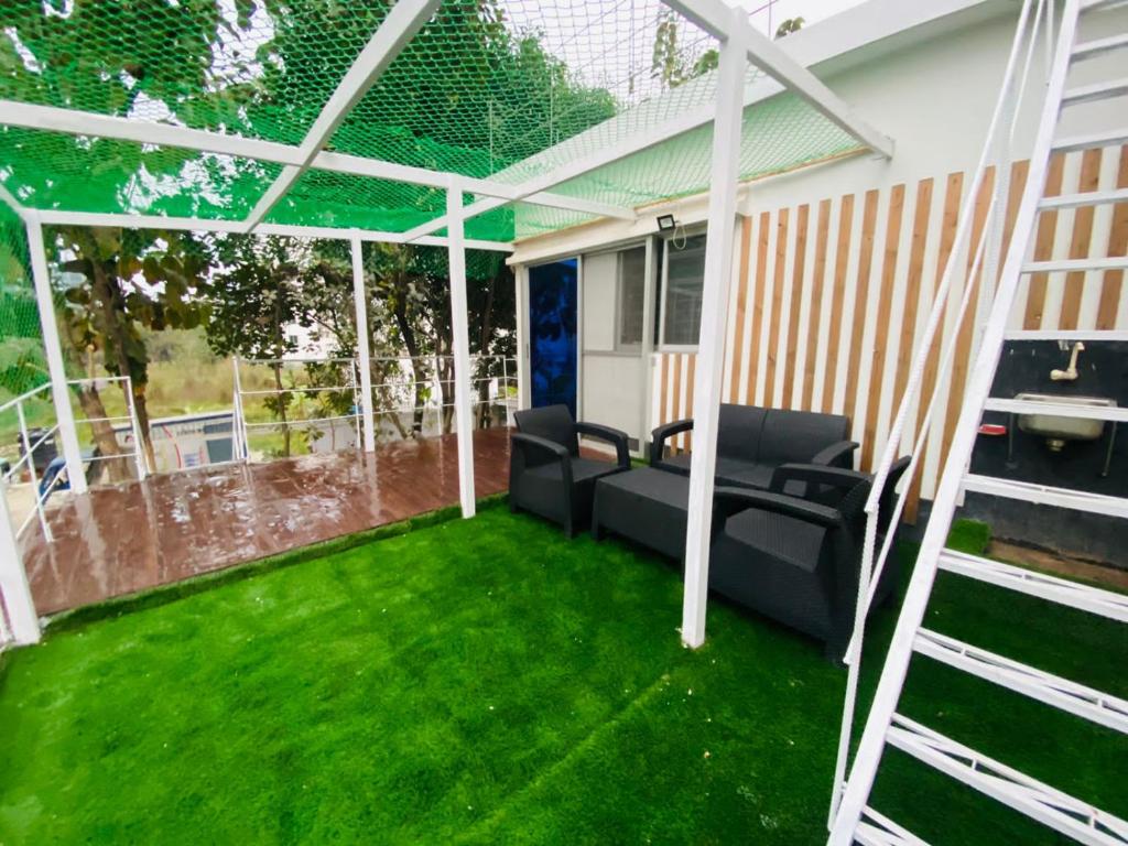 a screened in porch with a green lawn at Penthouse -Private Room with Attach bath Ac & Rooftop in Dhaka