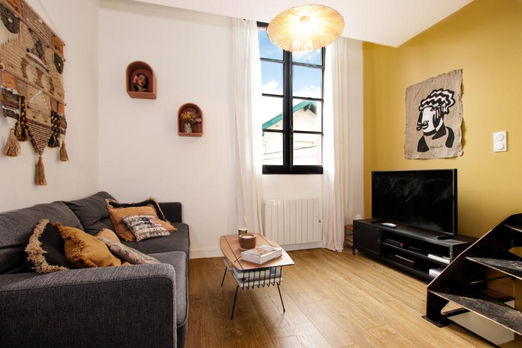 sala de estar con sofá y TV en Superbe maison au coeur de la ville à deux pas de la Côte des Basques, en Biarritz