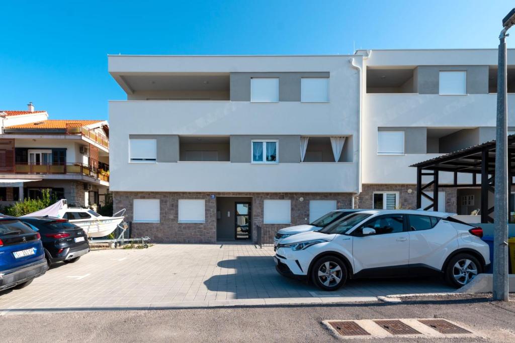 a white car parked in front of a building at Apartment APARTMAN MIA in Brodarica
