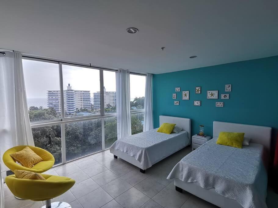 a bedroom with two beds and a large window at Apartamento de playa con vista al mar en coronado in Playa Coronado