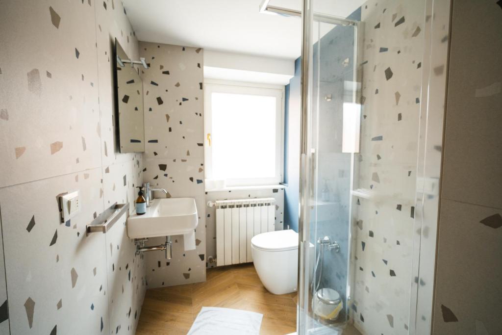 a bathroom with a toilet and a sink and a shower at Hurban Apartments Muggia in Muggia