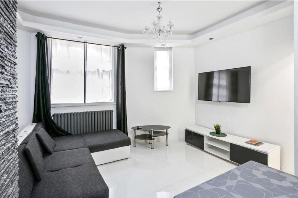 a living room with a couch and a tv at Stylish 2 bedroom apartment in Shoreditch - London in London
