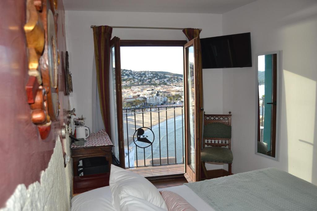 a bedroom with a bed and a door to a balcony at Hostal La Garita in Peniscola