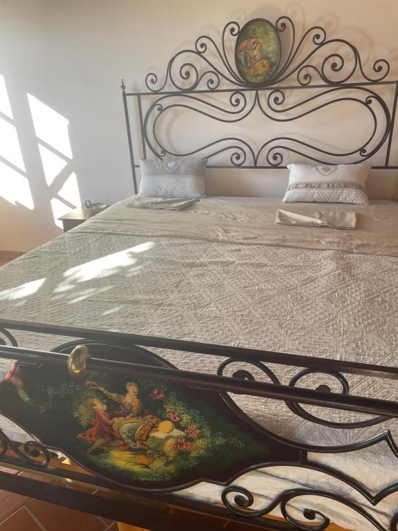 Una cama con un marco de metal con una pintura. en Villino Glicine, en Buti