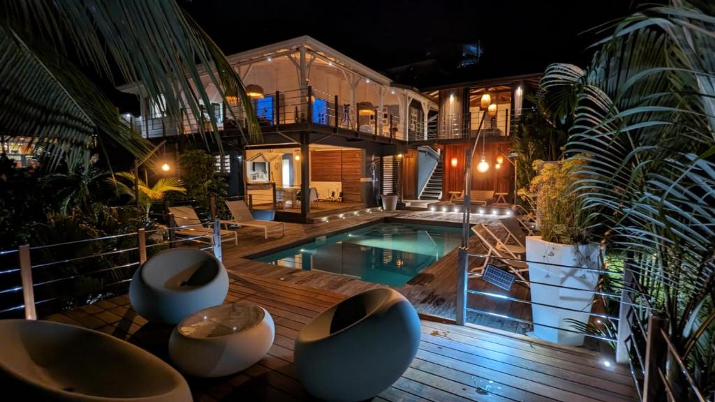 una casa con piscina di notte di Home Sweet Martinique a Le Marin