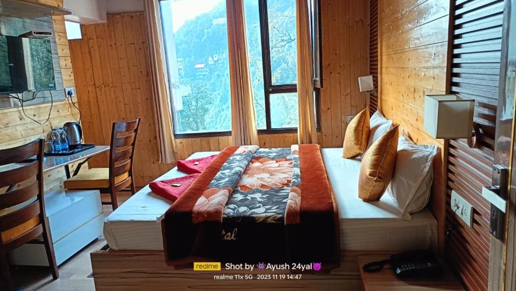 a bedroom with a bed in front of a window at HOTEL MA HEIGHTS in Dalhousie