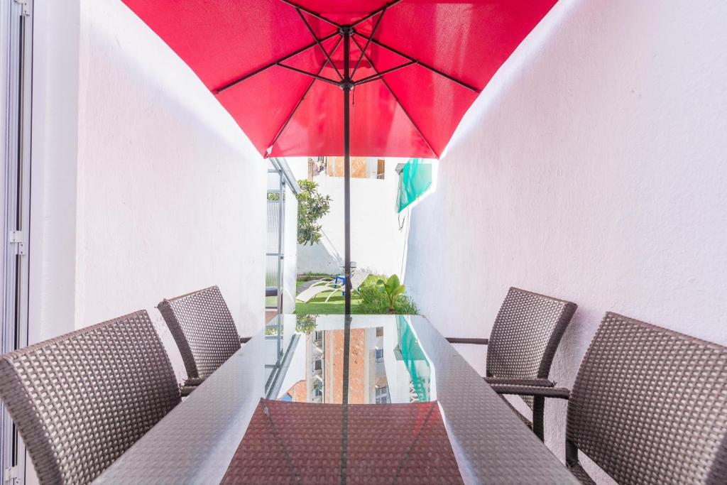 a table with a red umbrella in a dining room at HomeHolidaysRentals Arlene in Calella