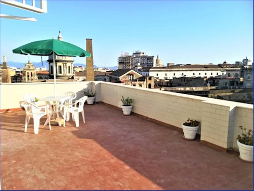 patio ze stołem i parasolem na dachu w obiekcie La Dimora delle Divinità w mieście Napoli