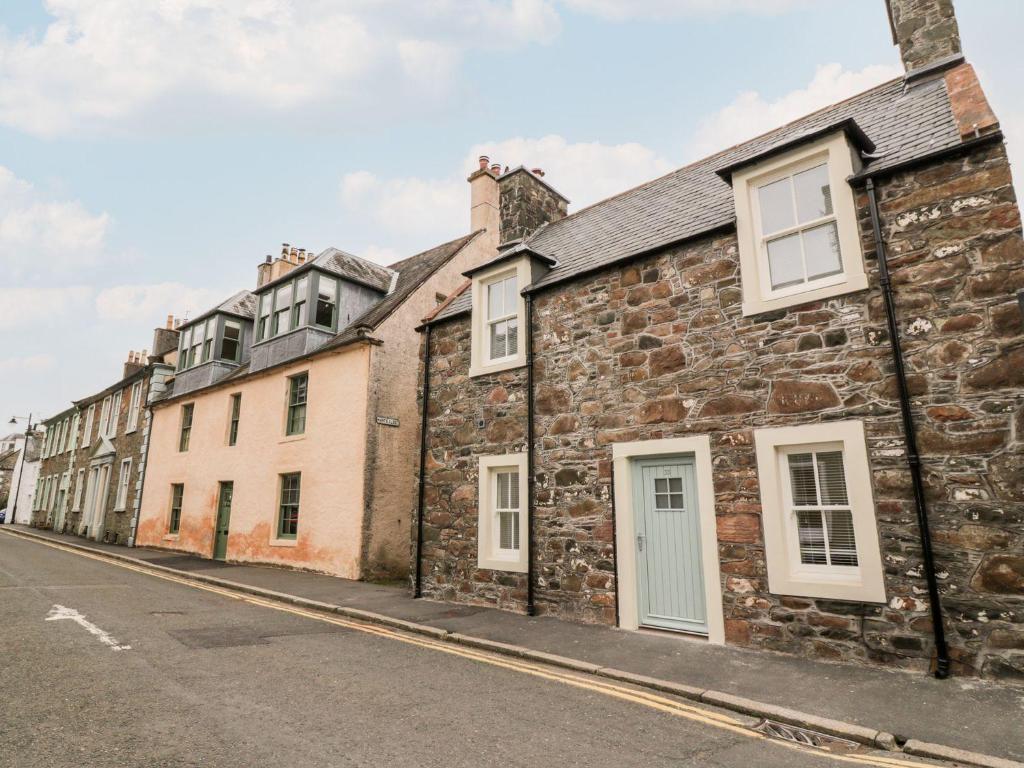 a row of old stone houses on a street at Harts Cottage in Kirkcudbright