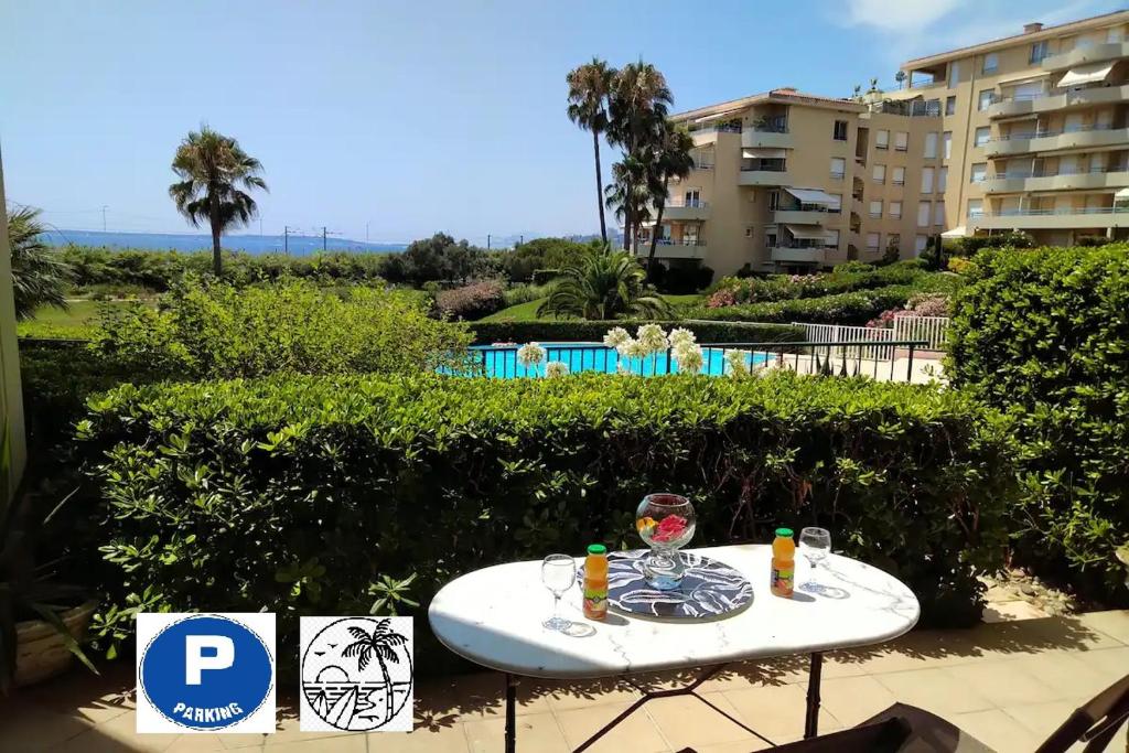 einen Tisch mit einem Getränk darüber neben einem Resort in der Unterkunft Antibes T2 Vue mer 48m2 Terrasse Parking Piscine Plage in Antibes