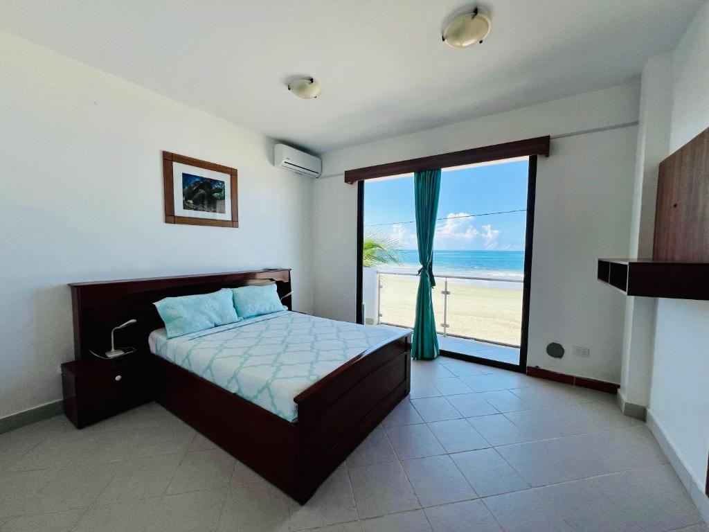 1 dormitorio con cama y vistas a la playa en Hotel Sierra Negra, en Puerto Villamil