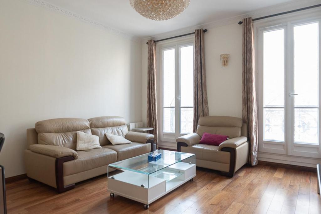 een woonkamer met een bank en een salontafel bij Spacious apartment with balcony in Parijs