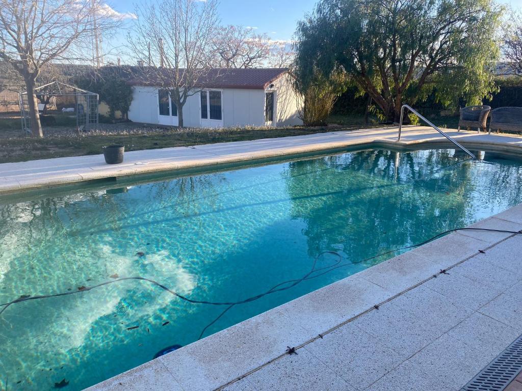 una piscina de agua azul en un patio en La Geneta Casa Vacacional, en Vilobí del Penedès