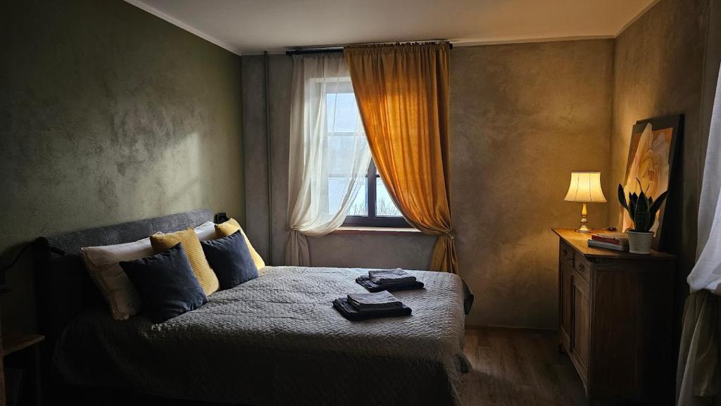 Dormitorio pequeño con cama y ventana en Promenādes apartamenti, en Talsi