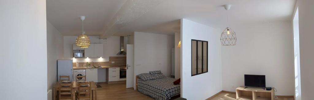 a living room and kitchen with a couch and a tv at Spacieux Studio in Mer