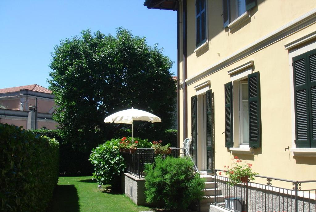 un parasol dans un jardin à côté d'un bâtiment dans l'établissement Alpi Giulie, à Intra