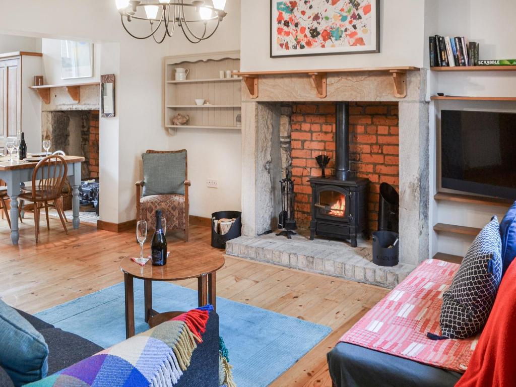a living room with a fireplace and a couch at Pitmans Cottage in Ryton