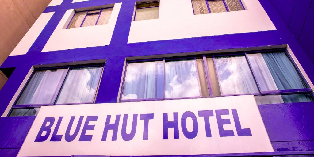 una señal azul caliente de hotel en el lateral de un edificio en Blue Hut Hotel en Nairobi