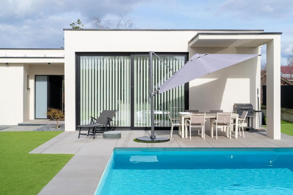 Casa con piscina, mesa y sombrilla en Splendide villa proche de Colmar en Bischwihr