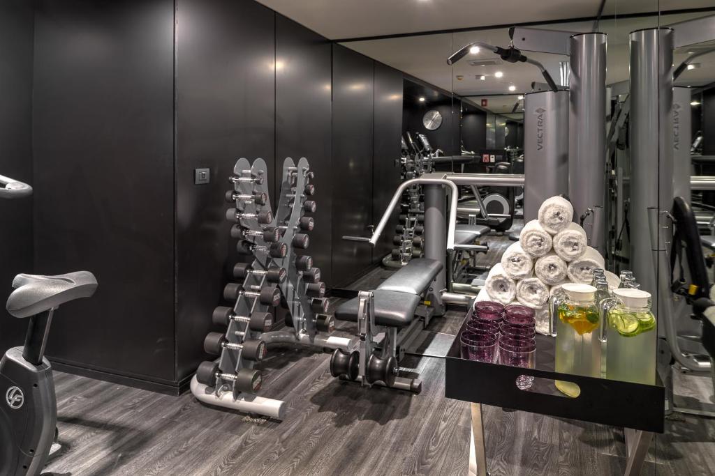 A compact, mirror-lined gym with cardio, strength equipment, and refreshments.