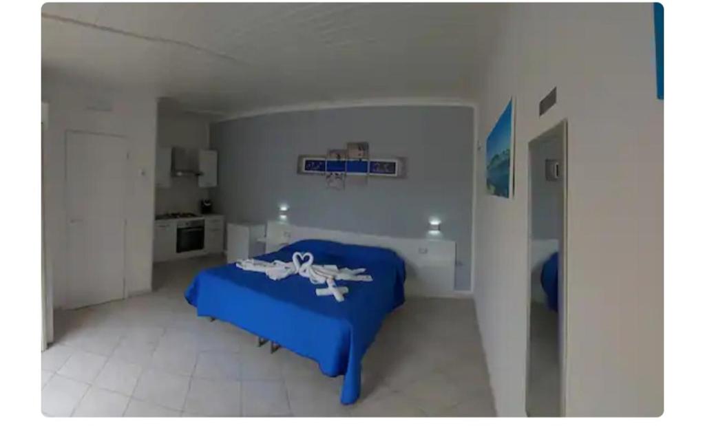 - une chambre blanche avec un lit bleu dans l'établissement Briciola's rooms, à Porto Cesareo